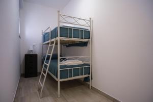 un letto a castello con una scala in una stanza di Case bianche del Capitolo a Monopoli