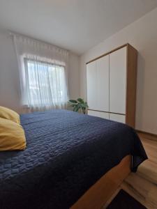 a bedroom with a bed and a dresser and a window at Medeni Apartma in Pivka