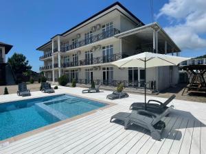 a hotel with a swimming pool and a building at Бугенвиллея in Lidzava