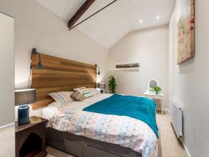 a bedroom with a large bed with a wooden headboard at CHESTER'S ONLY TIN CHAPEL - UNIQUE, SPACIOUS 2 BEDROOMS, GARDEN AND FREE PARKING in Chester