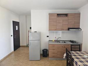 a kitchen with a white refrigerator and a sink at Horizonti Blu in Shëngjin