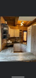a large kitchen with wooden cabinets and a table at Domek u Janiego in Milówka