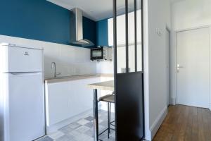 a kitchen with a counter and a refrigerator at LE PALAIS DES THERMES in Nancy