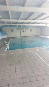 a swimming pool with blue water and a tile floor at Holiday Lodge, sleeps 4, with sea & countryside views in Ore +18 photos