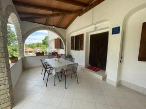 an outdoor patio with a table and chairs and an archway at Apartment Benky Pican in Pićan