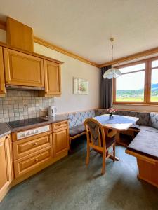 eine kleine Küche mit einem Tisch und einem Sofa in der Unterkunft Apartmenthaus Brigitte in Leutasch