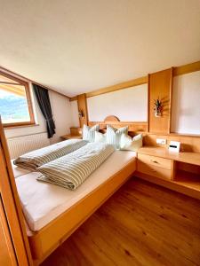 ein großes Bett in einem Zimmer mit Fenster in der Unterkunft Apartmenthaus Brigitte in Leutasch