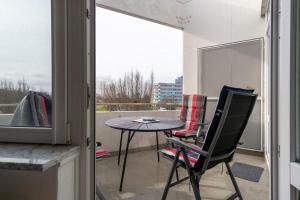 een patio met een tafel en stoelen op een balkon bij Haus-des-Kurgastes-Wohnung-4 in Heiligenhafen