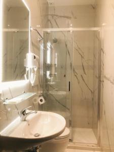 W łazience znajduje się prysznic, umywalka i toaleta. w obiekcie Hostel Cosmos w Rzymie