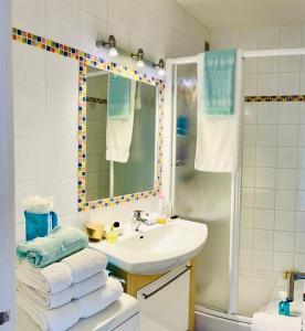 a bathroom with a sink and a shower with towels at Appartement Pearl Beach in Saint-Tropez