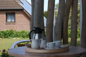 een dienblad met een koffiepot en kopjes op een tafel bij Dock2Apartment Rügen Whg 1 große Terrasse, ruhige Lage in Lohme