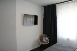 1 dormitorio con 1 cama y TV en la pared en Dock2Apartment Rügen Whg 1 große Terrasse, ruhige Lage, en Lohme