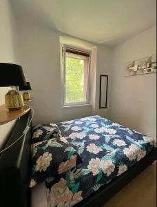 een slaapkamer met een bed met een bloemdekbed en een raam bij apartment Eva in Pula