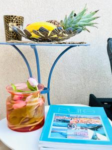 einen Tisch mit einem Buch und eine Vase mit Blumen in der Unterkunft Appartement Pearl Beach in Saint-Tropez