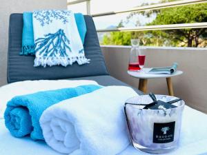 einen Tisch mit Handtüchern und eine Kerze auf dem Balkon in der Unterkunft Appartement Pearl Beach in Saint-Tropez