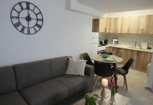 salon z kanapą i zegarem na ścianie w obiekcie Central Luxury Flat 2 w Chios
