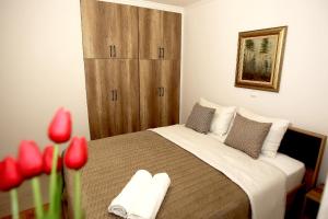 sypialnia z dużym łóżkiem z czerwonymi kwiatami w obiekcie Central Luxury Flat 2 w Chios