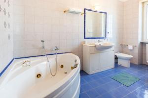 un bagno con vasca, lavandino e WC di Dimora dei Naviganti - 15 Min dalla Costiera Amalfitana Vista Mare con Jacuzzi a Salerno Altre 36 foto
