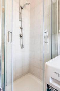 un bagno con doccia con porta in vetro di Dimora dei Naviganti - 15 Min dalla Costiera Amalfitana Vista Mare con Jacuzzi a Salerno