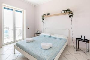una camera da letto con un letto con due cuscini sopra di Dimora dei Naviganti - 15 Min dalla Costiera Amalfitana Vista Mare con Jacuzzi a Salerno