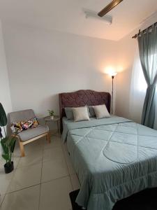 1 dormitorio con 1 cama y 1 silla en Qilayna guest room en Sepang