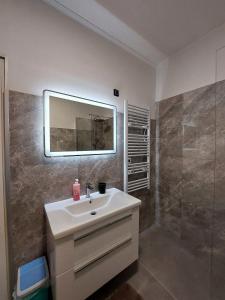 a bathroom with a sink and a mirror and a shower at Apartment Adriatic, Cres in Cres