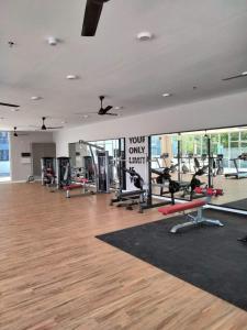 a gym with lots of treadmills and machines at Qilayna guest room in Sepang