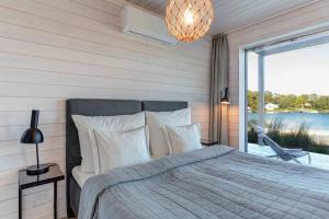 een slaapkamer met een bed en een groot raam bij Kasnäs Marina Seafront Lux Villa in Kasnäs