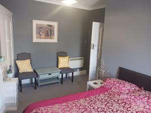 a bedroom with a bed and two chairs and a table at Llandudno Beachfront 2 Double Bedroom Apartment 2nd Floor in Llandudno