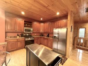 a kitchen with wooden cabinets and a stainless steel refrigerator at Grand View Home with 360 Degree Mountain View in Tellico Plains