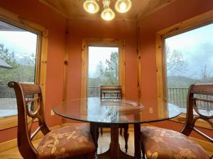 a dining room with a table and chairs and windows at Grand View Home with 360 Degree Mountain View in Tellico Plains
