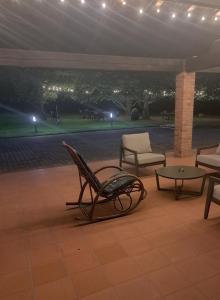eine Terrasse mit Stühlen, einem Tisch und Lampen in der Unterkunft Cascina Ravona in San Fermo della Battaglia
