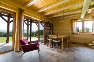 a dining room with a table and chairs and windows at Chata Buena Vista in Wawrzka
