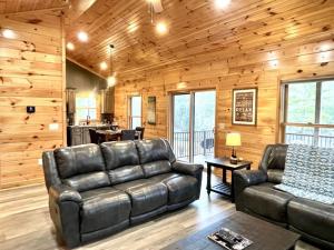 Peaceful Pearl Bear Home - Field Trails and Fishing Nearby في Tellico Plains: غرفة معيشة مع أريكة جلدية وطاولة