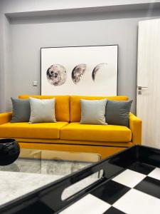 a yellow couch in a living room with a checkered floor at Aire in Tripoli