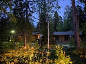 una casa en el bosque por la noche con árboles en Imatra Kylpyla Spa Entire Apartment, en Imatra