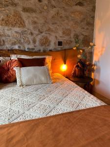 a bedroom with a large bed with a stone wall at Emily's House in Castro Daire