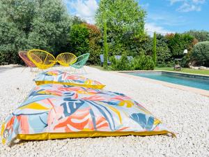 una cama con una manta colorida junto a una piscina en villa Luberon en Saint-Saturnin-dʼApt