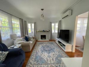 a living room with a couch and a tv at Beach House 100ms to Beach Freshly Renovated All New Appliances in Gold Coast