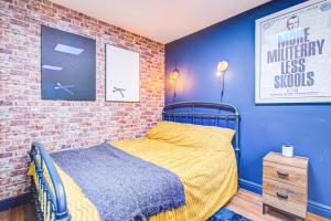 ein Schlafzimmer mit einem Bett und einer Ziegelwand in der Unterkunft Pass the Keys Cosy Studio flat near hospital in Westcliff On Sea