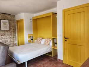 1 dormitorio con armarios amarillos y 1 cama. en Casiñas A Granxa en Vimianzo