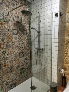y baño con ducha y pared de azulejos. en Casiñas A Granxa en Vimianzo