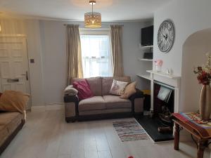 un soggiorno con divano e camino di Quaint cottage near to town, beach and station a Exmouth Altre 18 foto