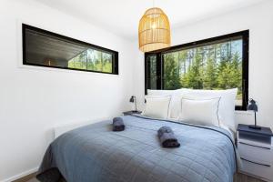 een slaapkamer met een groot bed en 2 ramen bij Villa Eslahti - Seafront/Jacuzzi in Porvoo