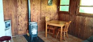 a wooden room with a table and a stove at Domek letniskowy in Górzno