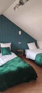 - une chambre avec 2 lits avec des draps verts dans l'établissement la madeleine, à Saint-Benoît-sur-Loire