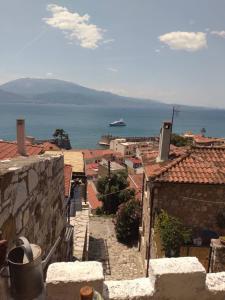 Blick auf eine Stadt mit einem Boot im Wasser in der Unterkunft Stone Clock's House in Nafpaktos