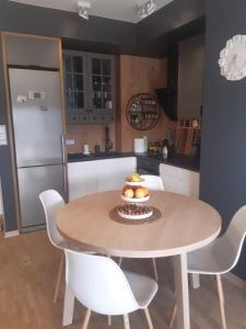 a kitchen with a table with a bowl of fruit on it at Apartament nr 9 Mazurskie Klimaty in Tomaszkowo