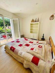 een slaapkamer met een bed met een quilt bij Maison à 5min Calanques in Ensuès-la-Redonne