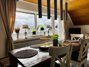 a dining room with a table and a large window at Ferienhaus Greta in Mastershausen
